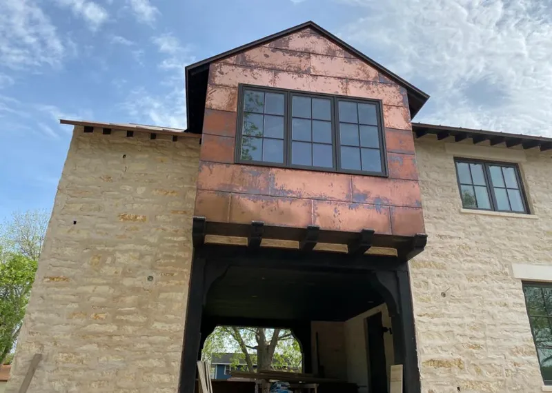 Copper metal panel facade on a stone building for Skylight Installation in Country Club Estates