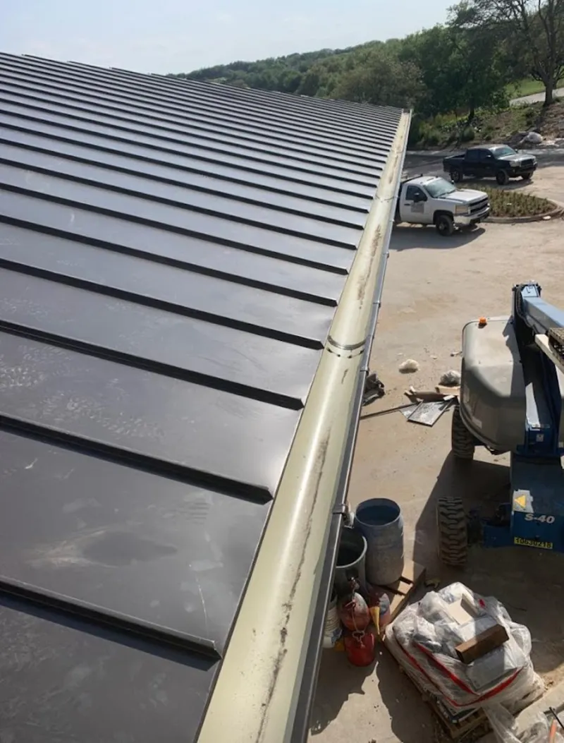 Standing seam panel and gutter detail on a metal roofing jobsite in Country Club Estates